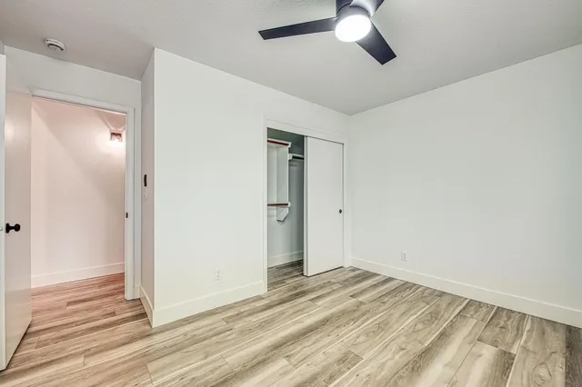 a view of a room with wooden floor and ceiling fan