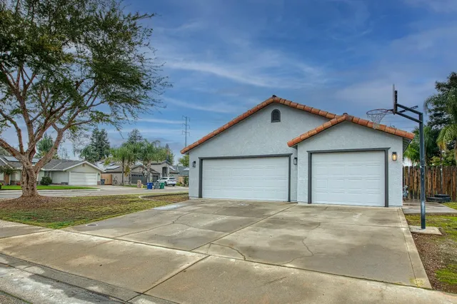 a front view of a house with a garden and garage