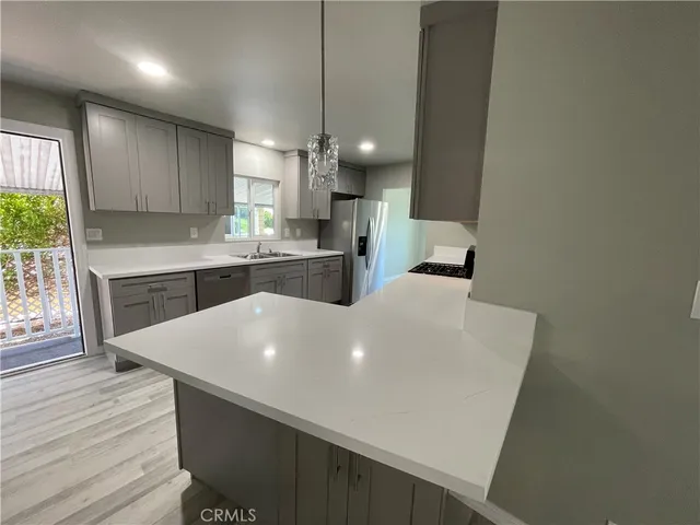 a large white kitchen with a white table chairs and a refrigerator