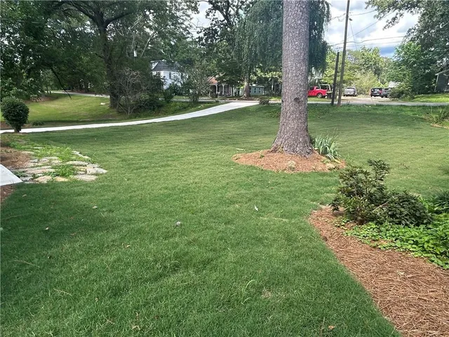 a view of a house with backyard and sitting area