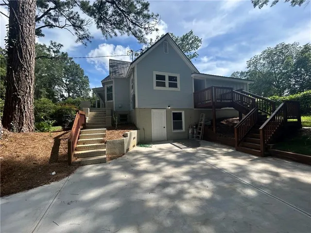 an empty room with wooden floor a fireplace and a kitchen space