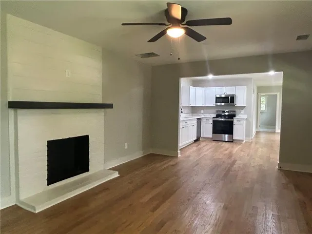 an empty room with windows and fireplace