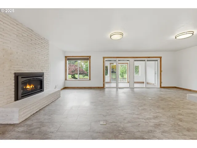 a view of an empty room with a fireplace and a window