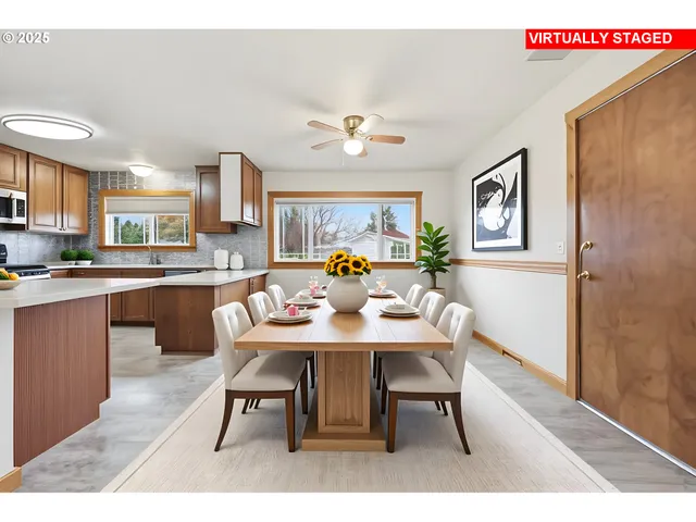 a living room with stainless steel appliances kitchen island a table and chairs