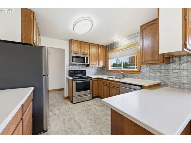 a kitchen with stainless steel appliances a stove sink microwave and cabinets