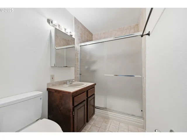 a bathroom with a granite countertop sink toilet a mirror and shower
