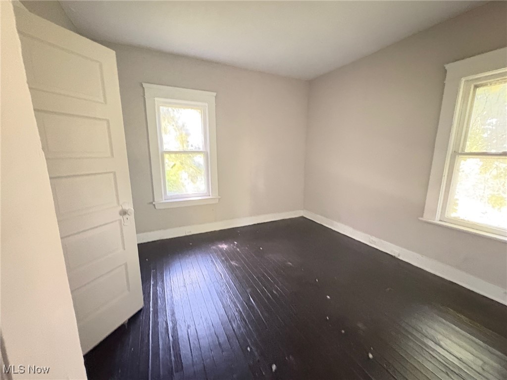 13802 Rugby Road Cleveland, OH 44110 - Photo 8 of 15 Unfurnished room with baseboards and dark wood-style floors