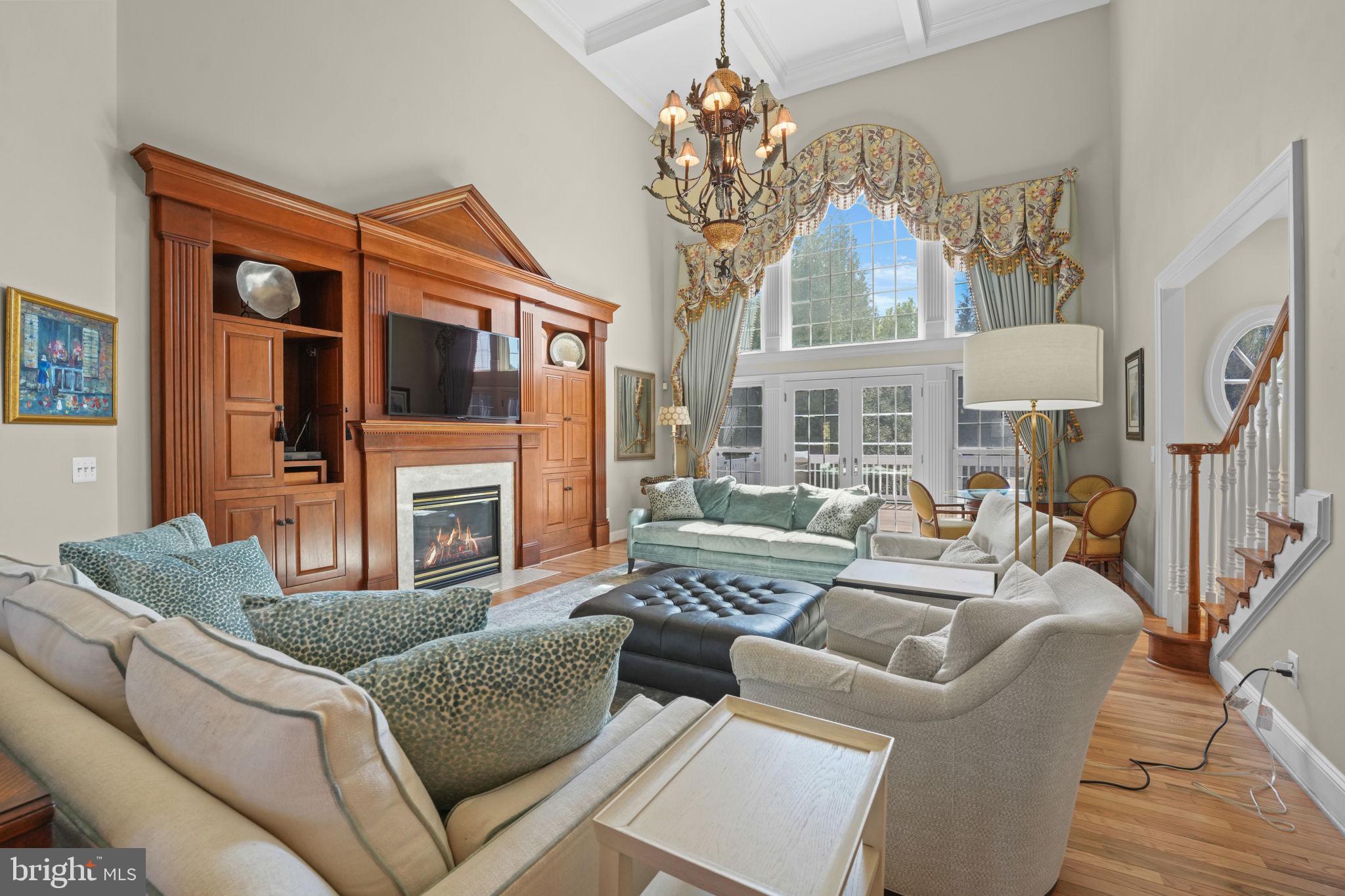 11431 Woolington Road Great Falls, VA 22066 - Photo 12 of 49 a living room with furniture a fireplace and a chandelier