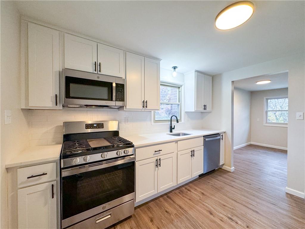 152 William Circle McKees Rocks, PA 15136 - Photo 4 of 16 a kitchen with cabinets stainless steel appliances a sink and wooden floor