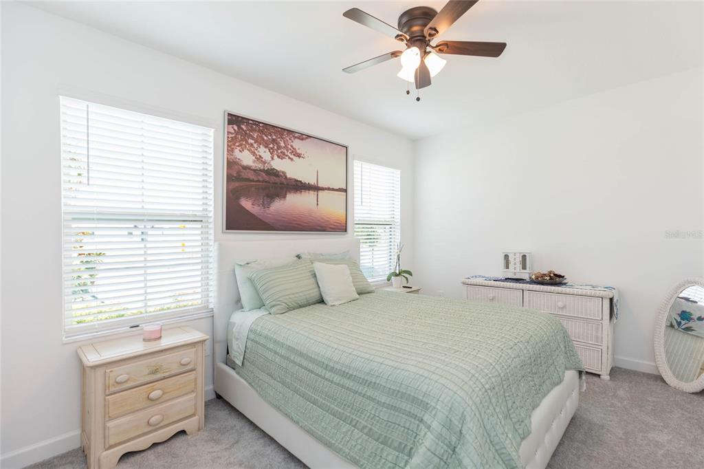 10806 Gable Dig Loop San Antonio, FL 33576 - Photo 33 of 73 a bedroom with a bed and a chandelier