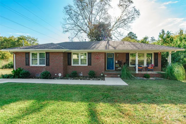 a front view of a house with a yard and green space