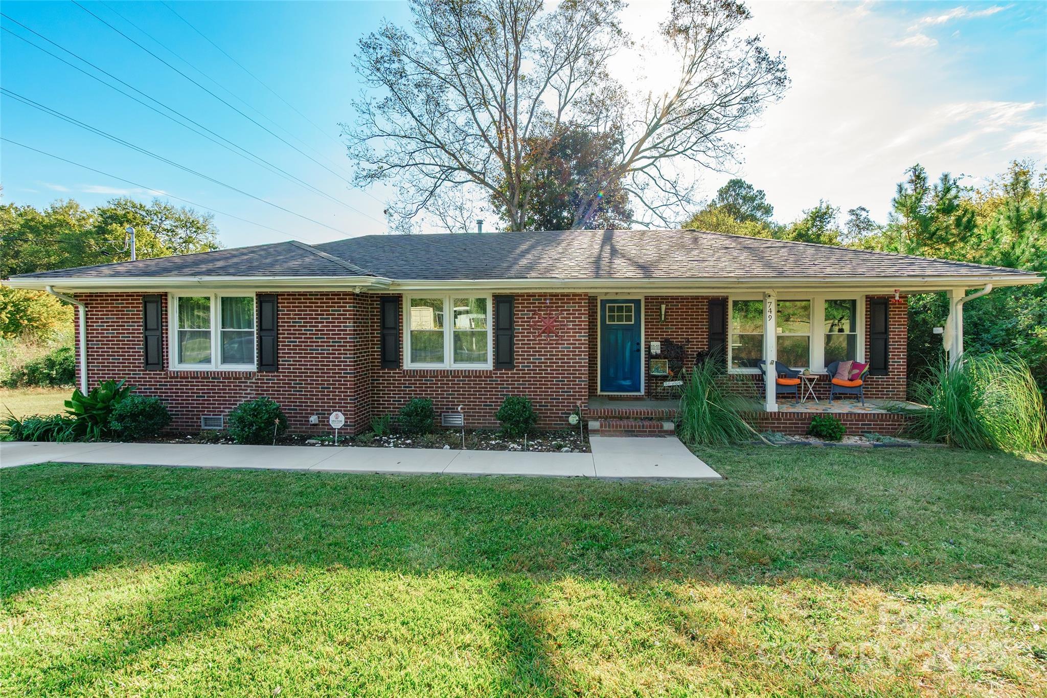 a front view of a house with a yard and green space