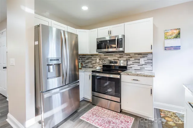 a kitchen with stainless steel appliances a refrigerator stove and microwave