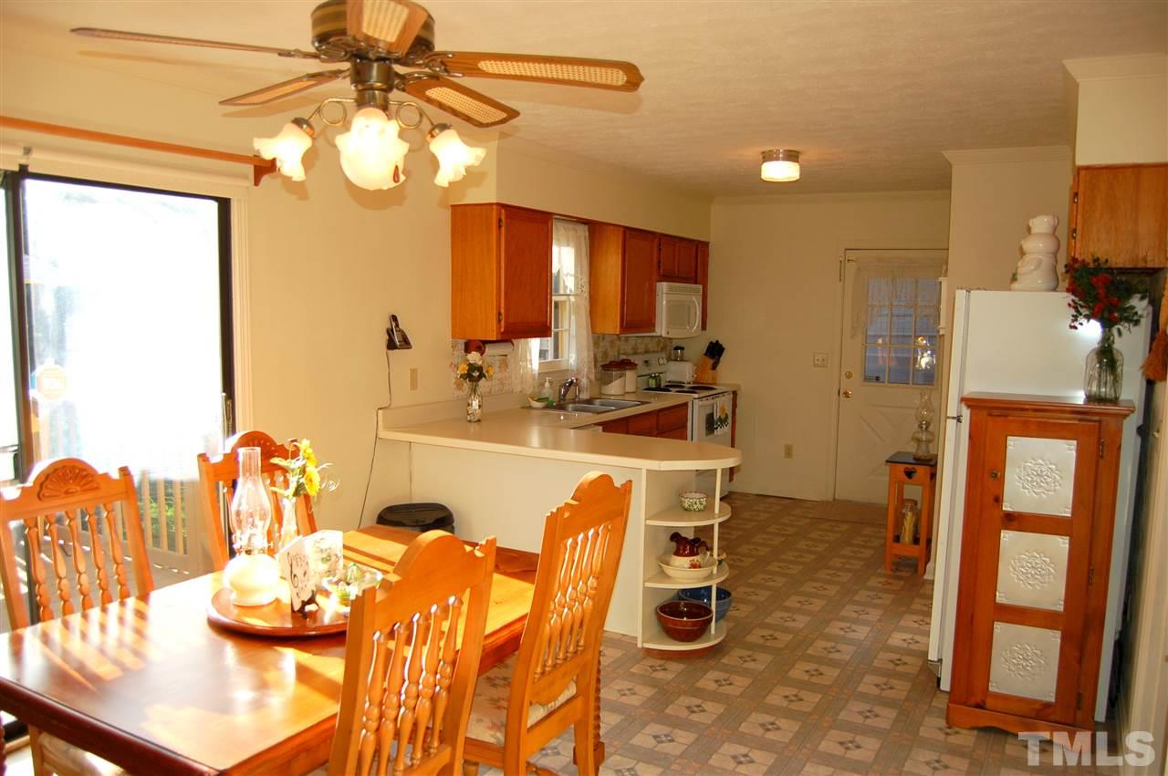 6109 Russell Road Durham, NC 27712 - Photo 7 of 25 a dining room with stainless steel appliances furniture a chandelier and kitchen view