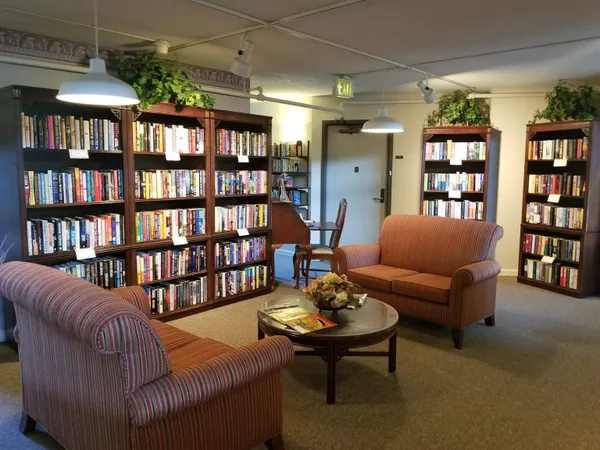 a living room with furniture and a book shelf