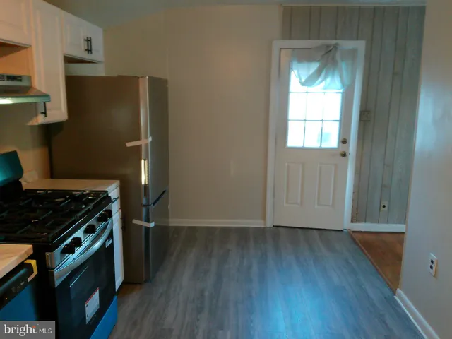 a kitchen with a wooden floor and a stove top oven
