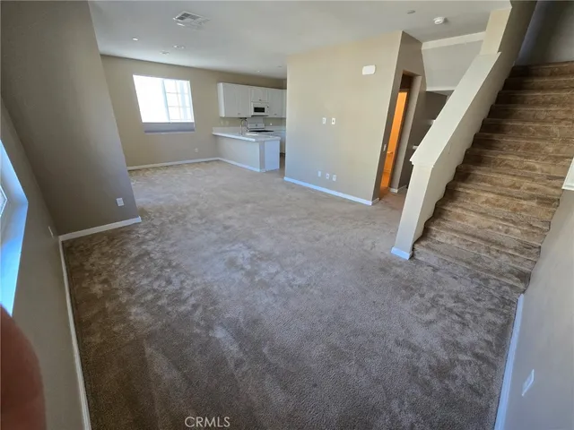 a view of a hallway to rooms and stairs