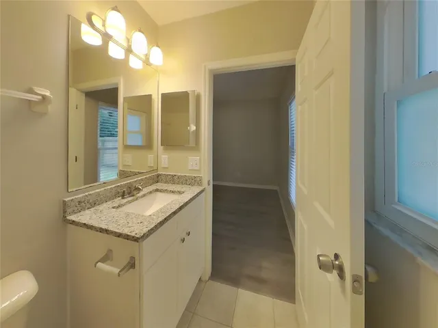 a bathroom with a granite countertop sink a toilet and a mirror