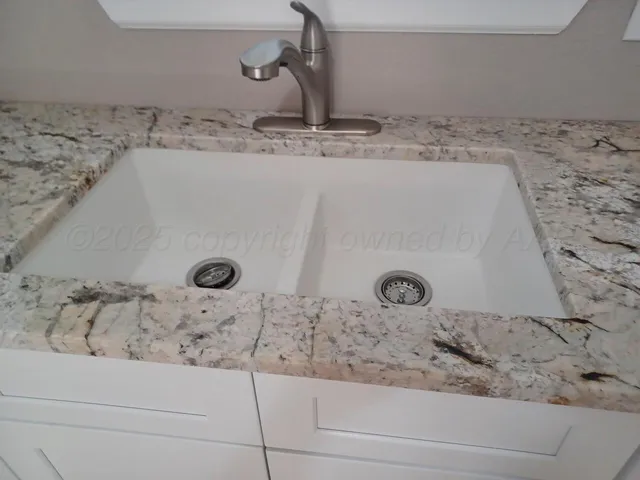 a bathroom with a granite countertop sink and mirror