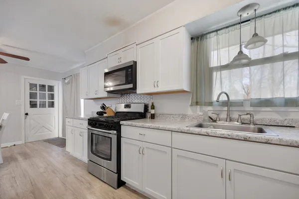 a kitchen with appliances a sink and cabinets
