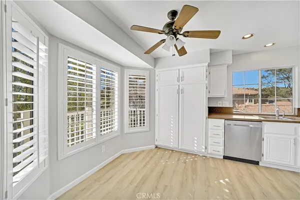a view of a kitchen with a sink hardwood floor and a ceiling fan