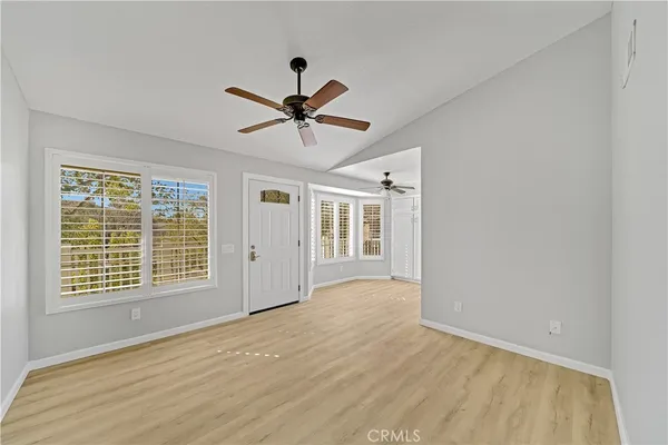 a view of an empty room with a window and a ceiling fan