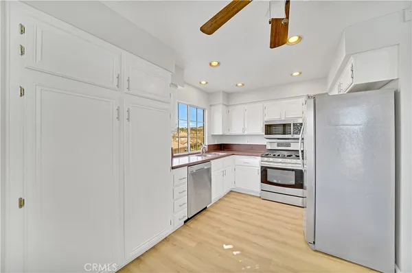 a kitchen with stainless steel appliances a refrigerator and a stove top oven