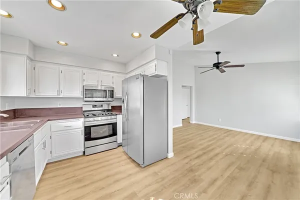 a kitchen with granite countertop a refrigerator and a stove top oven