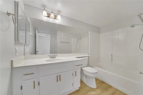 a bathroom with a sink a toilet and a large mirror