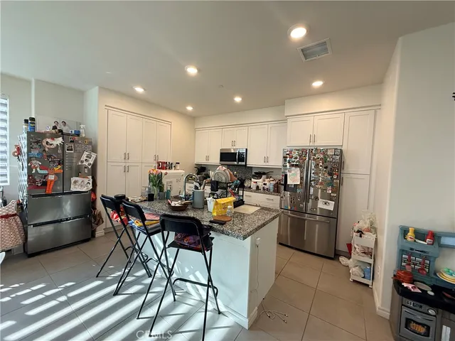 a bathroom with a double vanity sink a toilet a mirror and shower