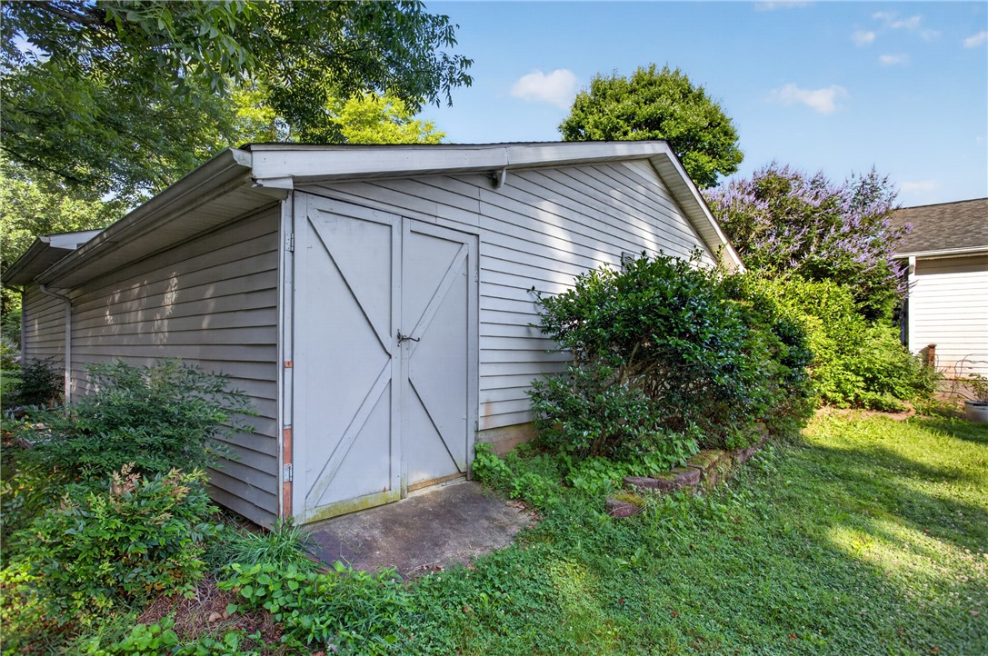 103 Dorsey Lane Walhalla, SC 29691 - Photo 27 of 42 A quaint outbuilding offers additional storage and utility amidst flourishing greenery.