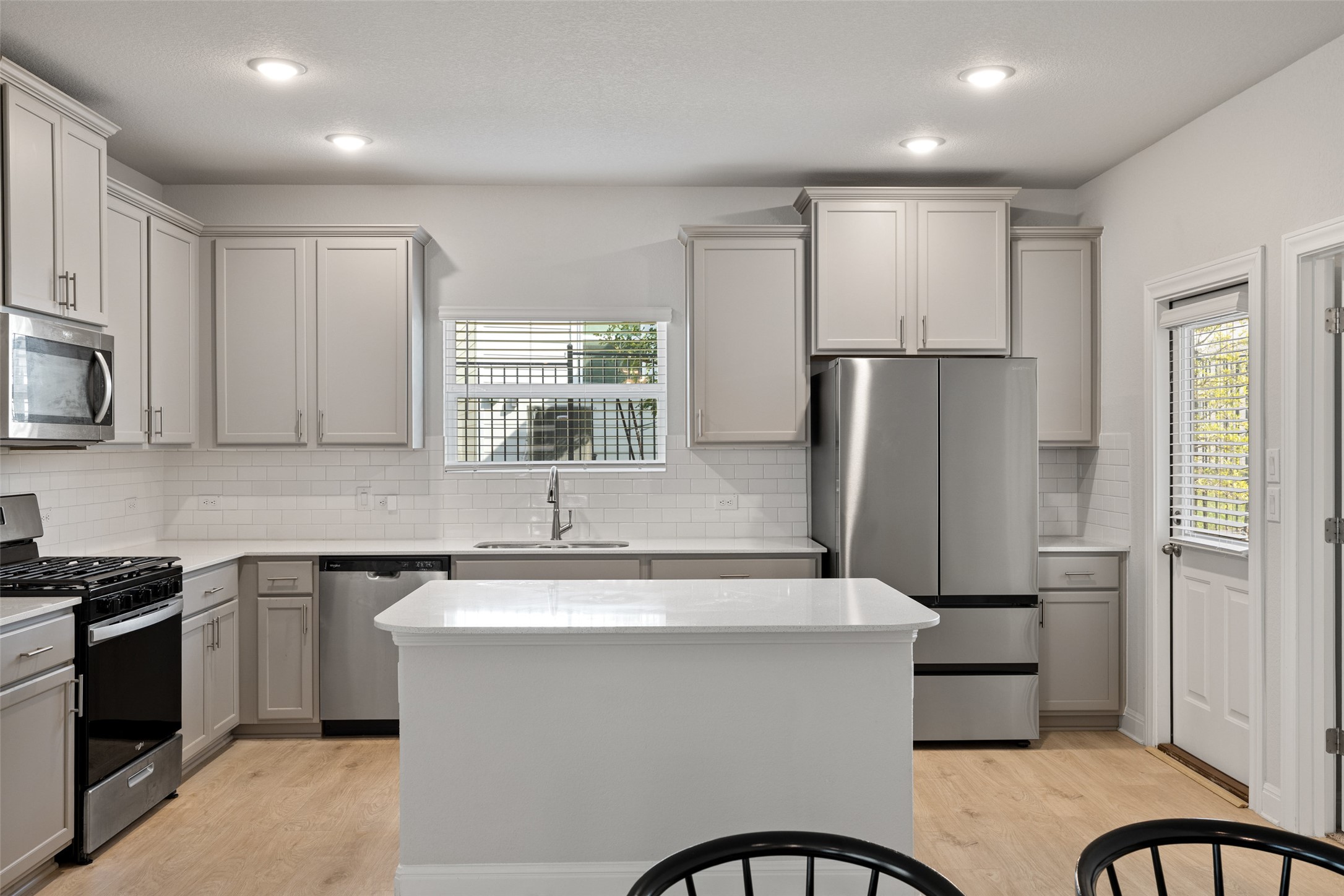 1012 Legend Milton Lane Austin, TX 78748 - Photo 10 of 30 a kitchen with stainless steel appliances a sink a stove a refrigerator cabinets and a window