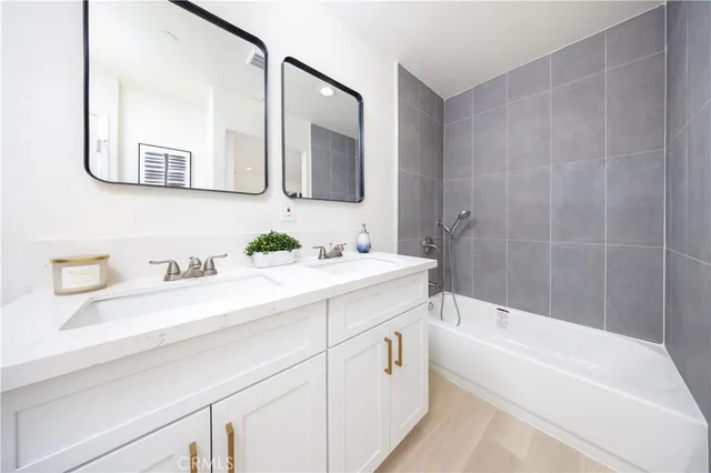 a bathroom with a bathtub a mirror a sink and vanity