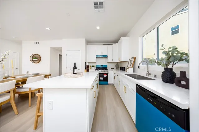 a kitchen with a sink a counter top space stainless steel appliances and a large window