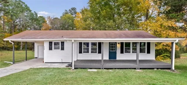 a view of a house with a yard balcony and a tree