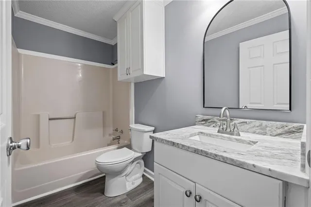 a bathroom with a granite countertop sink toilet a large mirror and shower