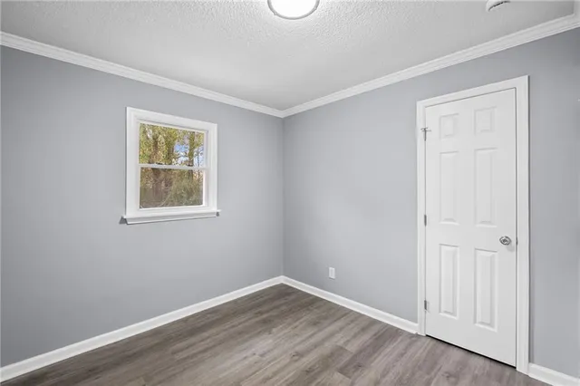 an empty room with a window and wooden floor