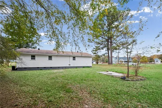 a view of a house with a yard and a large tree