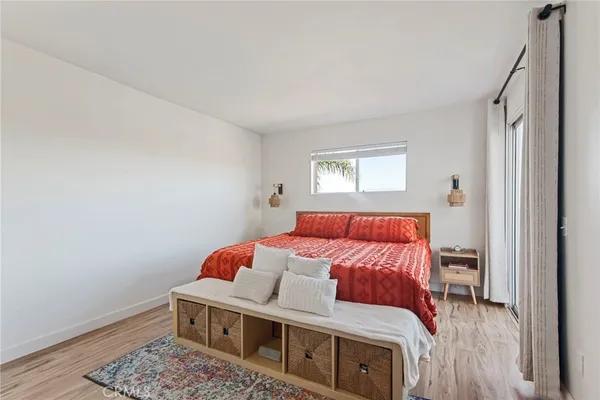 a bedroom with a large bed and a potted plant
