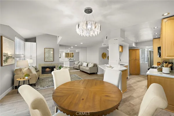 a living room with furniture kitchen view and a chandelier