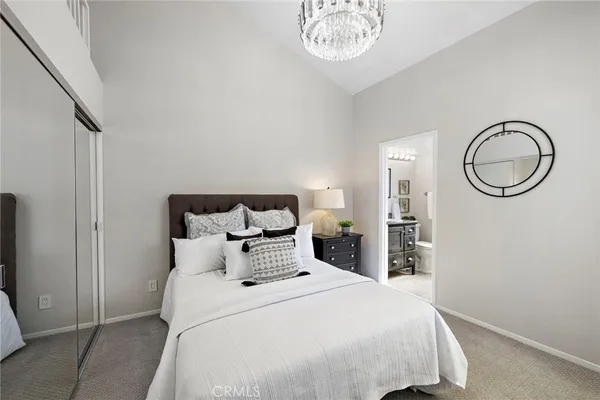 a bedroom with a bed and a chandelier