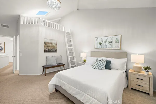 a bedroom with a bed and a lamp on dresser