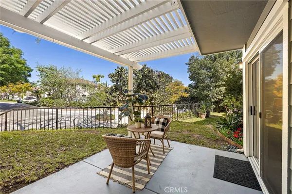 a patio with table and chairs and potted plants