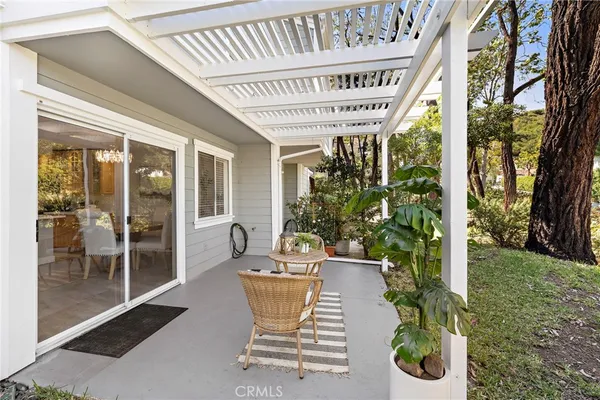 a patio with table and chairs and potted plants