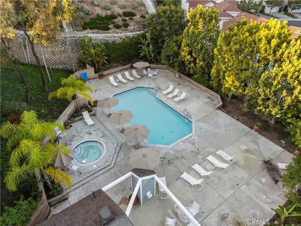 an aerial view of a swimming pool with outdoor seating