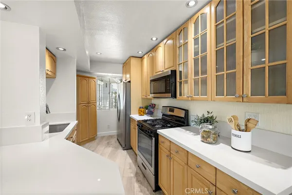 a kitchen with stainless steel appliances a sink a stove and a refrigerator