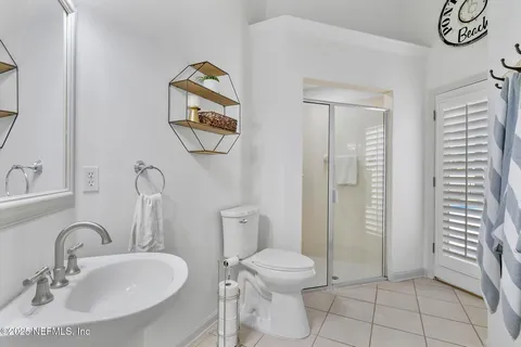 a bedroom with a large bed chandelier and a window