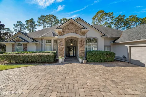 a front view of a house with a garden and yard