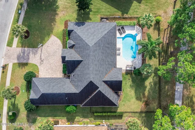 a view of backyard with swimming pool and green space