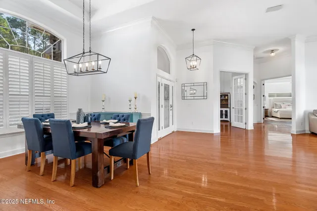 a view of a dining room with furniture a chandelier and wooden floor